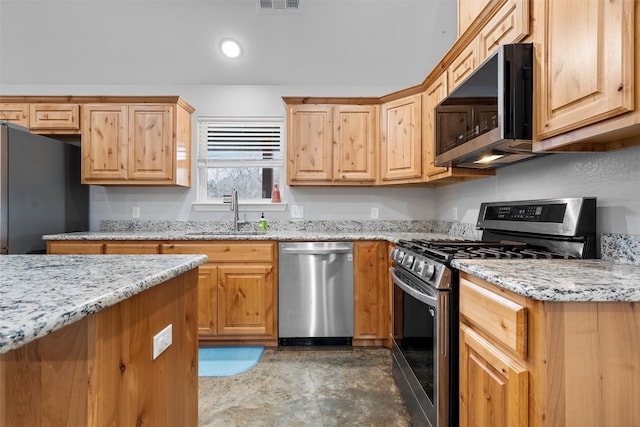 kitchen with stainless steel appliances, sink, and light stone counters