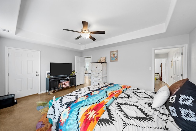 bedroom with ceiling fan and a tray ceiling