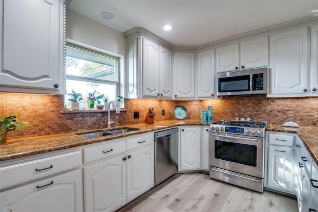 kitchen featuring white cabinetry, sink, stone countertops, and appliances with stainless steel finishes