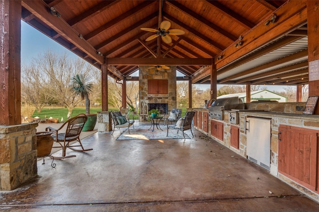 view of patio / terrace featuring area for grilling, ceiling fan, a gazebo, and an outdoor stone fireplace