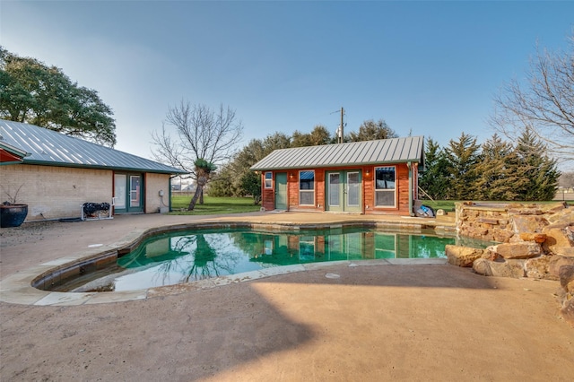 view of swimming pool with an outdoor structure and a patio area