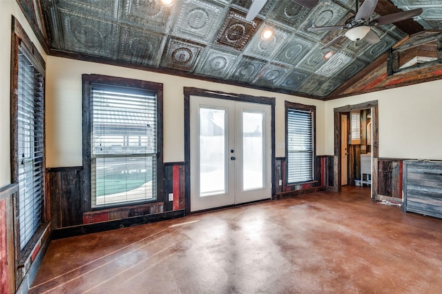 interior space with french doors, ceiling fan, lofted ceiling, and concrete flooring