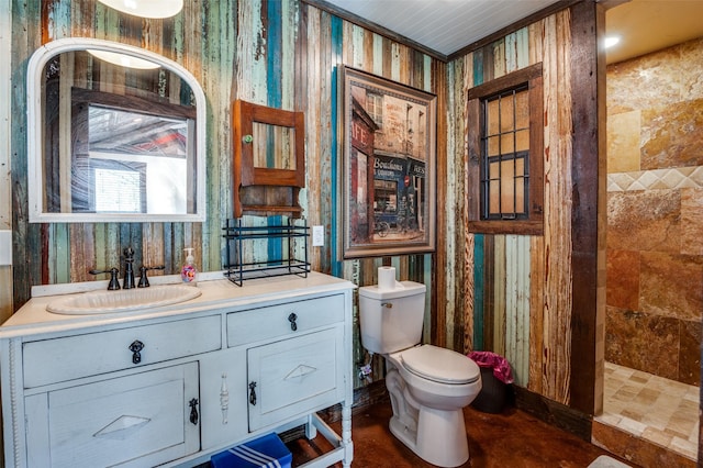 bathroom with vanity, toilet, and a tile shower