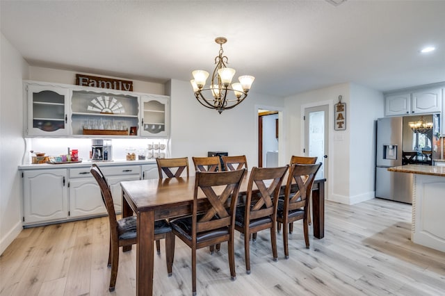 dining room with a notable chandelier and light wood-type flooring