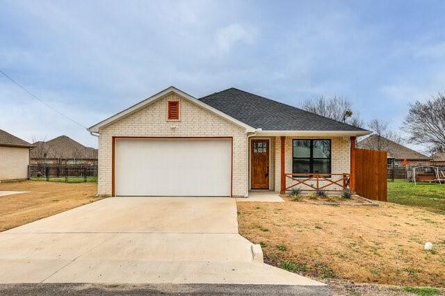 ranch-style home featuring a garage and a front lawn