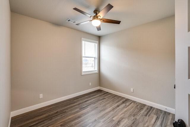 empty room featuring ceiling fan and dark hardwood / wood-style flooring