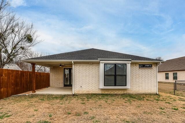 rear view of property with a lawn, ceiling fan, and a patio area