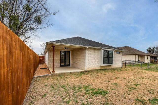 back of property featuring a yard, ceiling fan, and a patio area