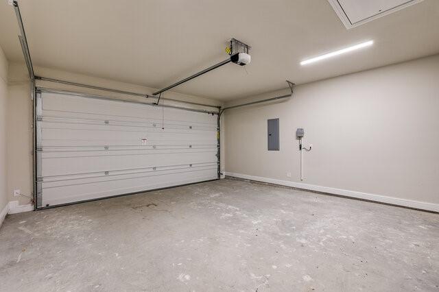 garage with a garage door opener and electric panel