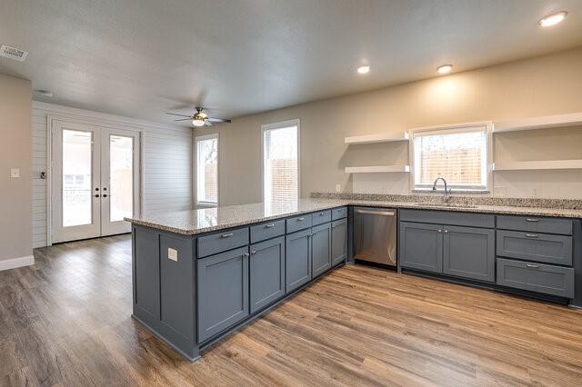 kitchen with french doors, dishwasher, sink, and kitchen peninsula