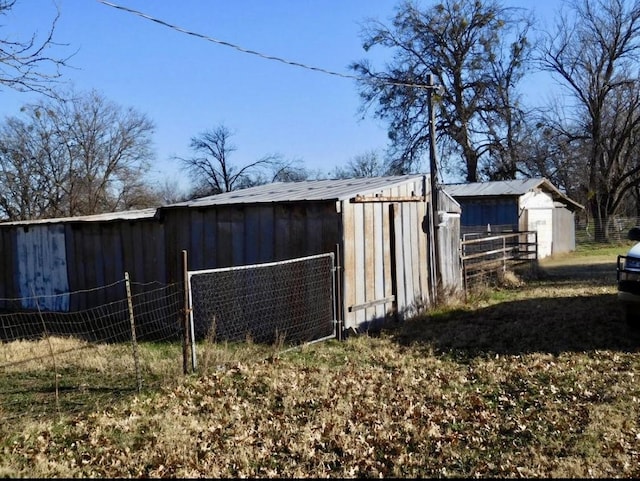 view of outdoor structure featuring an outbuilding and fence