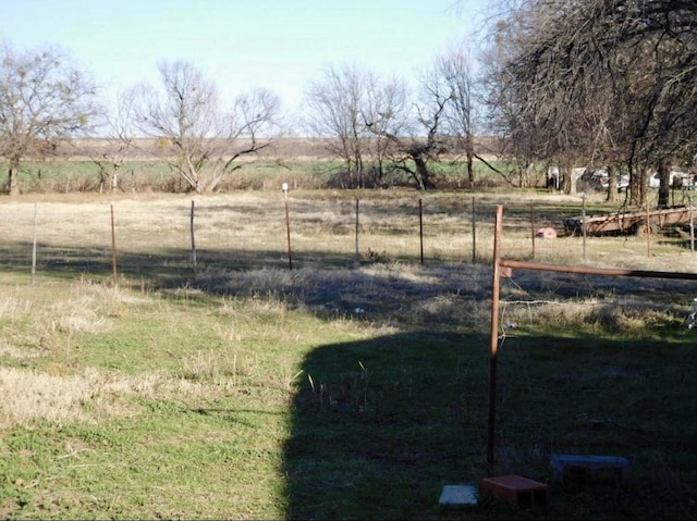 view of yard featuring fence and a rural view