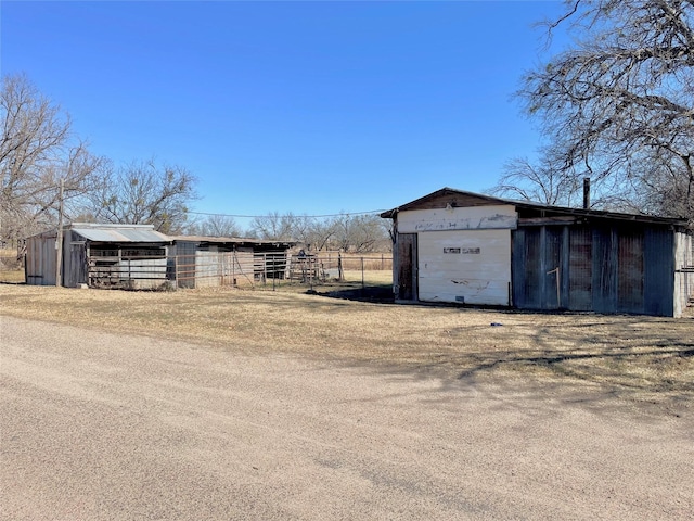 exterior space with an outbuilding, a pole building, and fence