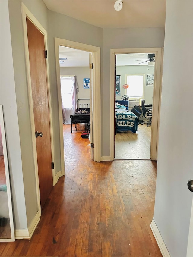hall with hardwood / wood-style flooring and baseboards