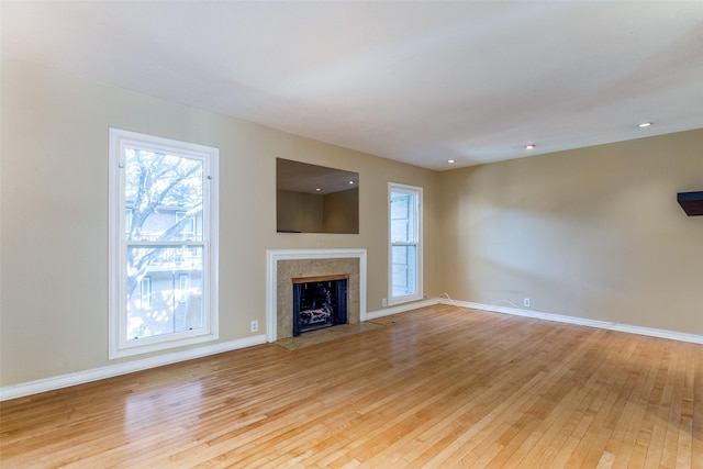 unfurnished living room featuring a premium fireplace and light wood-type flooring