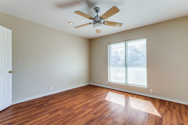 spare room with dark hardwood / wood-style floors and ceiling fan