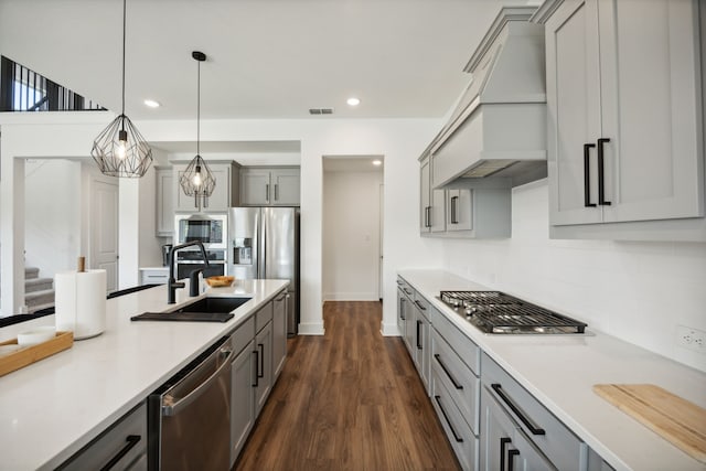 1209 Xeresa Dr, Little Elm, TX 75068 - kitchen with a sink, appliances with stainless steel finishes, gray cabinetry, backsplash, and custom exhaust hood