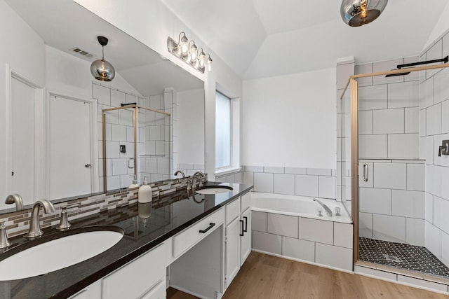 bathroom featuring lofted ceiling, backsplash, hardwood / wood-style flooring, and independent shower and bath