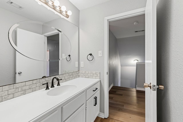 bathroom with wood-type flooring, backsplash, and vanity