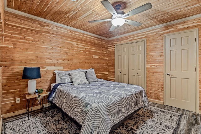 bedroom with wooden walls, ornamental molding, wooden ceiling, and a closet