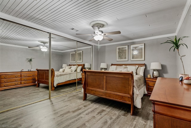 bedroom with ceiling fan, a closet, visible vents, and wood finished floors