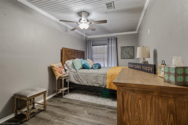 bedroom with baseboards, crown molding, visible vents, ceiling fan, and wood finished floors