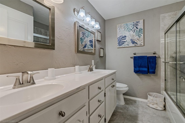 full bath featuring bath / shower combo with glass door, double vanity, a sink, and toilet