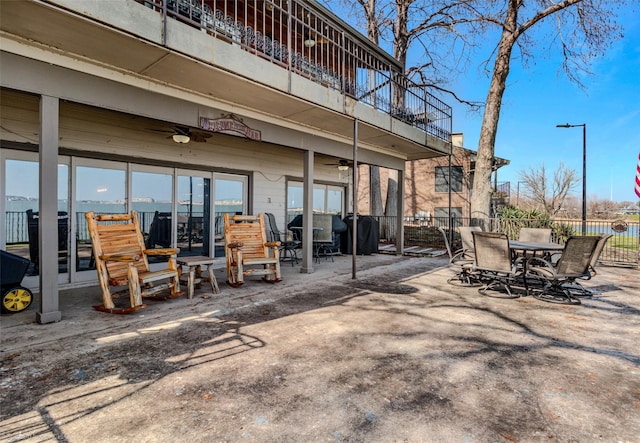 back of property featuring a ceiling fan, a patio, fence, a balcony, and outdoor dining area