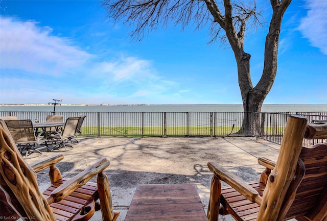 view of patio with a water view and outdoor dining space