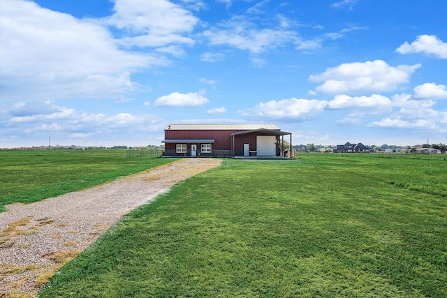 exterior space with a garage, a yard, and a rural view