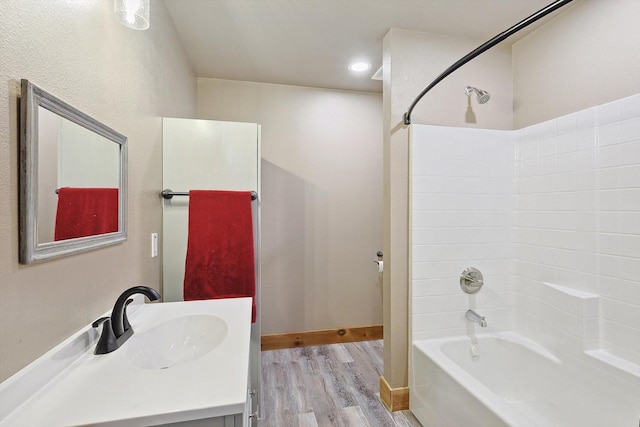 bathroom with hardwood / wood-style flooring, vanity, and tub / shower combination