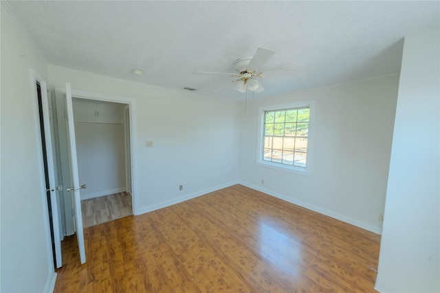 empty room featuring hardwood / wood-style flooring, ceiling fan, and a textured ceiling