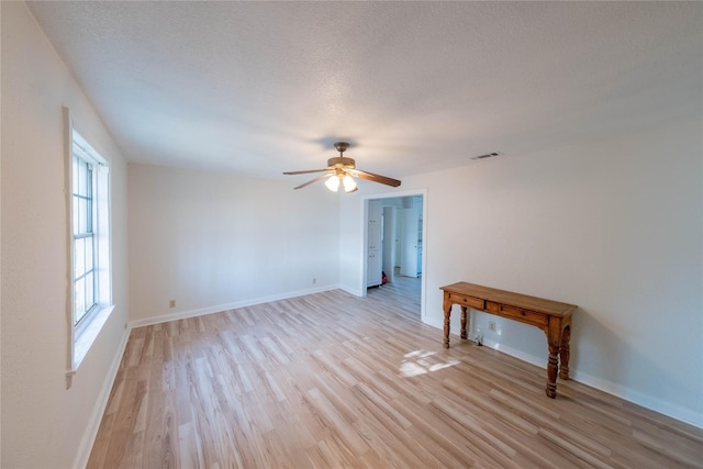 unfurnished room featuring ceiling fan, light hardwood / wood-style floors, and a textured ceiling