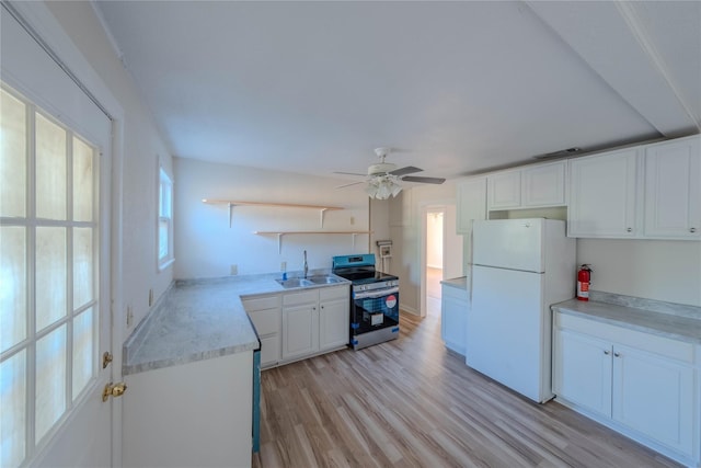 kitchen featuring sink, stainless steel electric range oven, white refrigerator, light hardwood / wood-style floors, and white cabinets