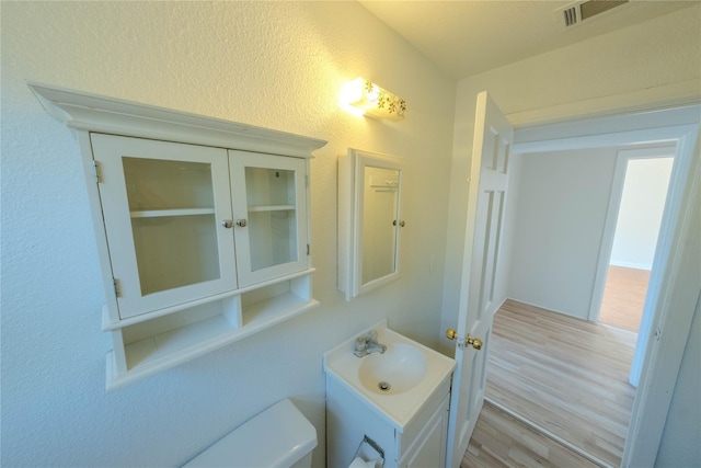 bathroom with vanity, hardwood / wood-style floors, and toilet