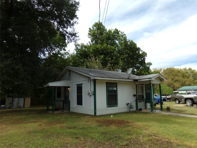 view of front of home with a storage unit and a front lawn