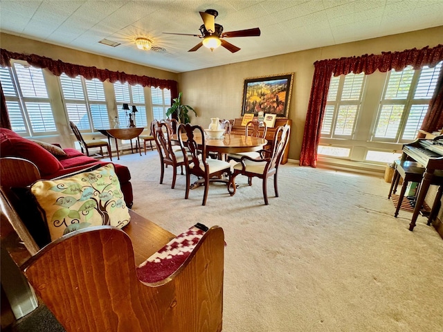 dining room with light colored carpet and ceiling fan