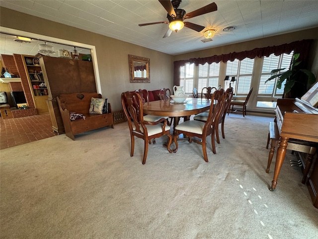 carpeted dining room with ceiling fan