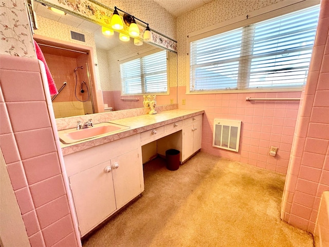 bathroom with vanity, tile walls, and walk in shower