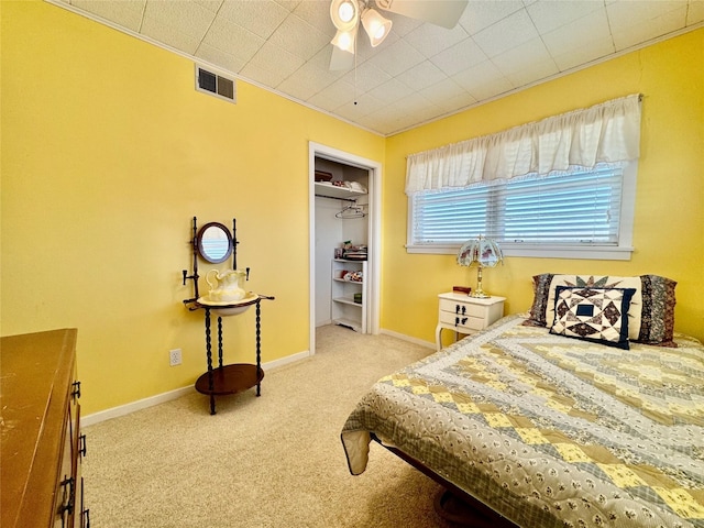 carpeted bedroom with crown molding, ceiling fan, and a closet