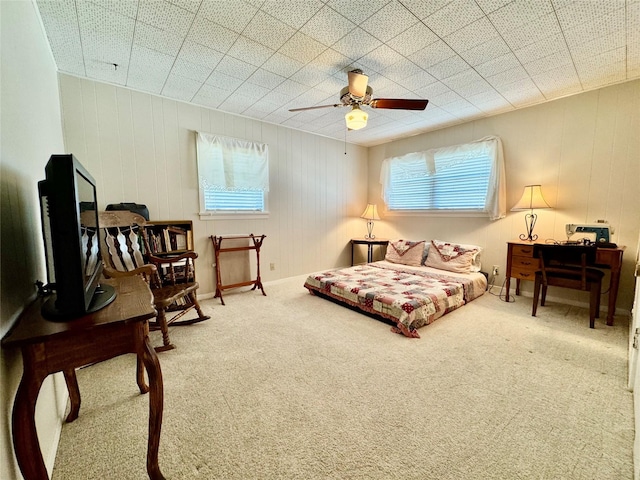 bedroom with ceiling fan, carpet flooring, and multiple windows