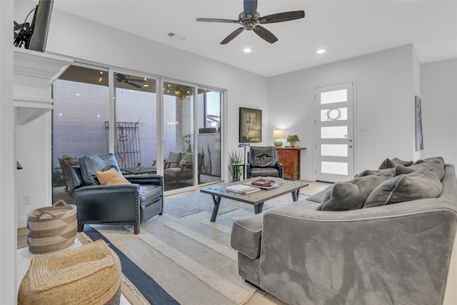 living room with a wealth of natural light, ceiling fan, and light hardwood / wood-style flooring