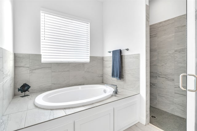 bathroom featuring separate shower and tub