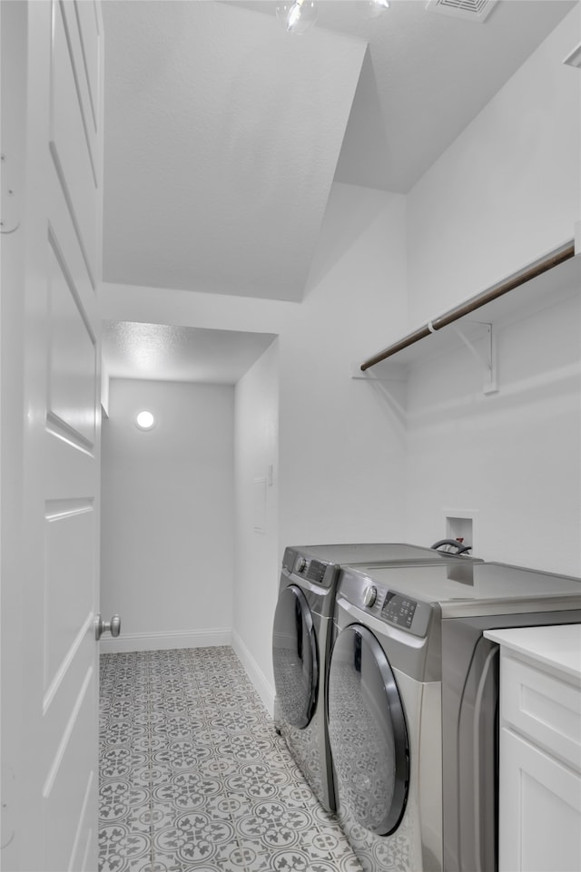 laundry room featuring cabinets and washer and dryer