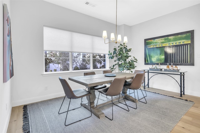 dining area featuring hardwood / wood-style floors and a chandelier