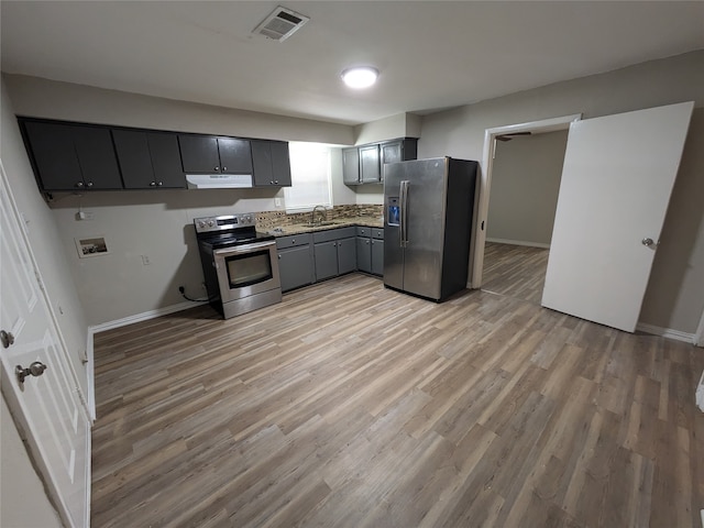 kitchen featuring sink, light wood-type flooring, gray cabinets, and appliances with stainless steel finishes