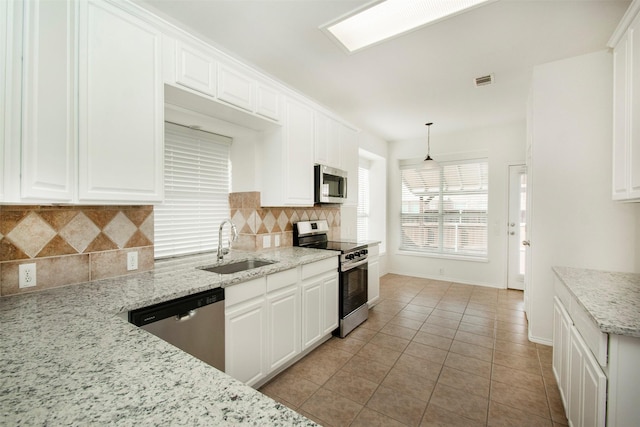 kitchen with stainless steel appliances, hanging light fixtures, and white cabinets