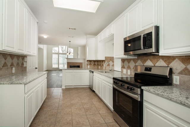 kitchen featuring stainless steel appliances, white cabinetry, and decorative light fixtures