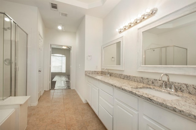 bathroom featuring tile patterned flooring, vanity, and a shower with door