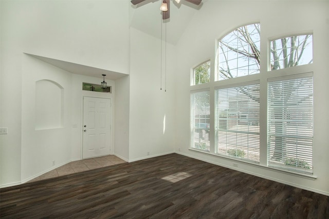 interior space with dark wood-type flooring, ceiling fan, and high vaulted ceiling